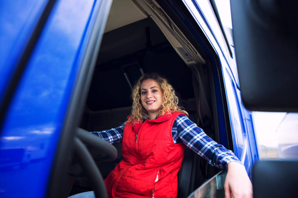 Conductrice de poids lourd souriante assise dans sa cabine