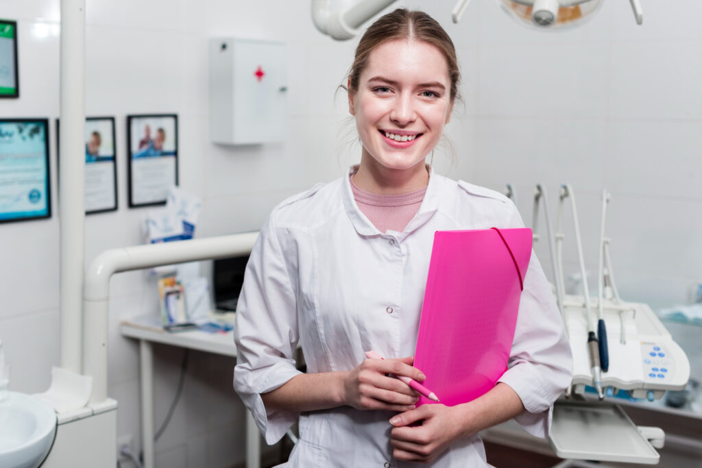 apprenti assistante dentaire tient une pochette rose dans ses mains elle est souriante