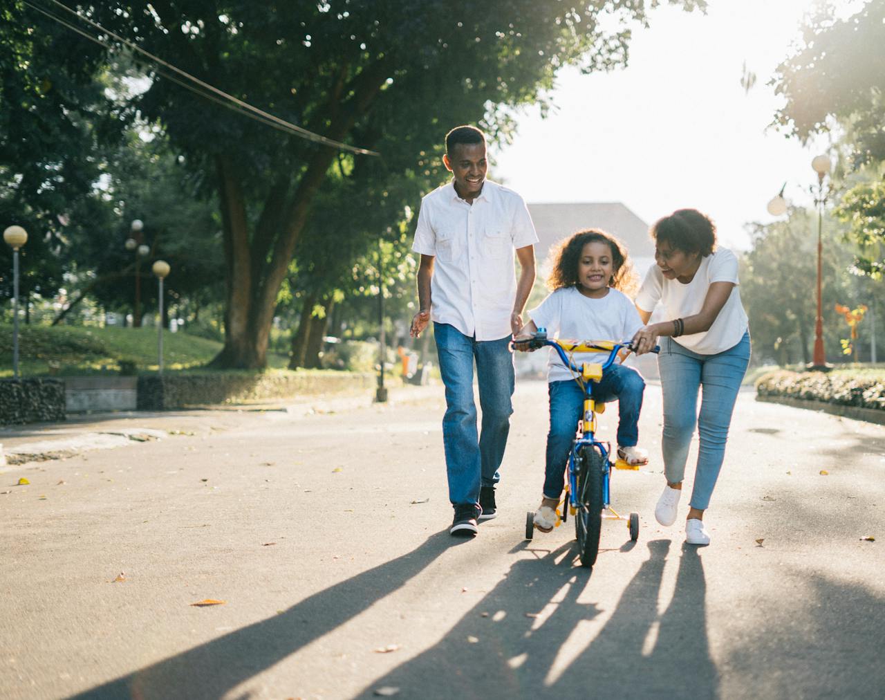 why-choose-us Happy family teaching their child to cycle on a sunny day outdoors.